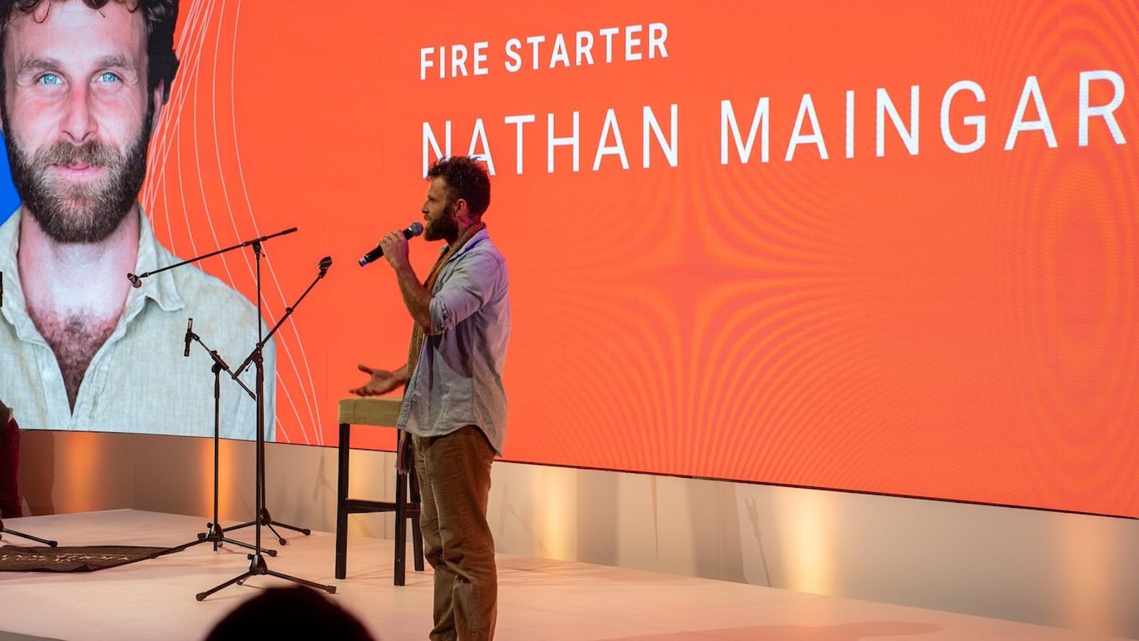 Nathan Maingard on stage at EO Ignite, introduced on the big screen as a Fire Starter speaker